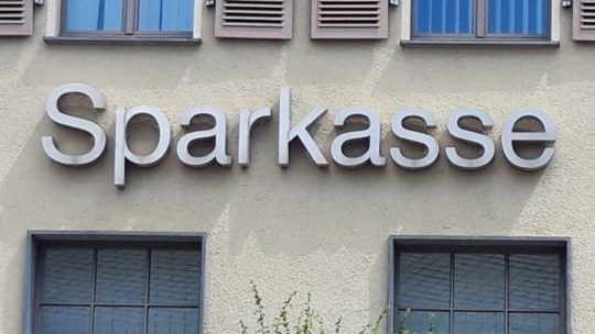 Gebäudewand mit werbeschriftzug "Sparkasse" in silbernen Buchstaben